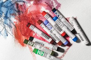 Assorted Daniel Smith Watercolour Sticks on a painted background
